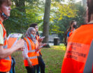 Students gathered in Temple Church Gardens wearing high vis carrying clipboards