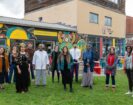 Community and project contributors standing in front of the St Pauls Community Cafe , new outdoor street furniture and colourful murals