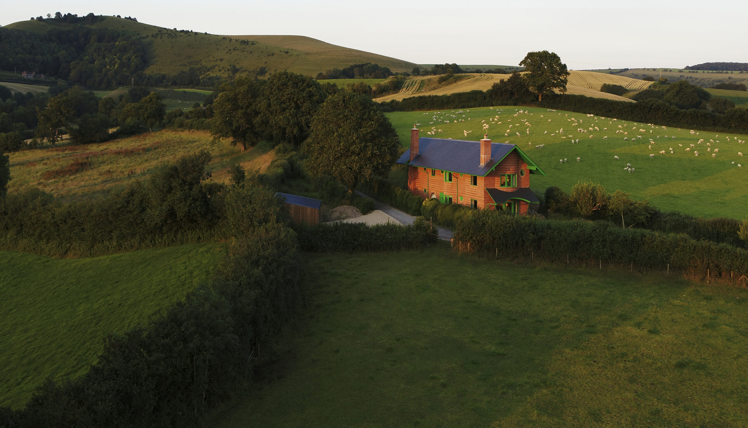 Red House surrounded by green fields.